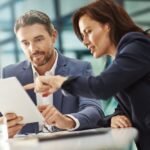 Dos profesionales revisan juntos una tableta en una oficina